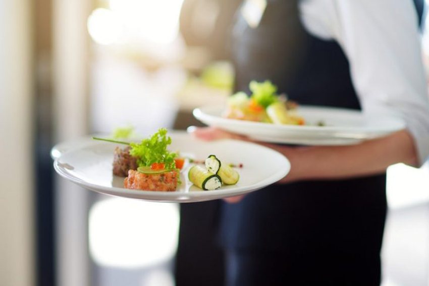 Kellner von Kultur Genuss serviert ein Gericht im Theater-Restaurant